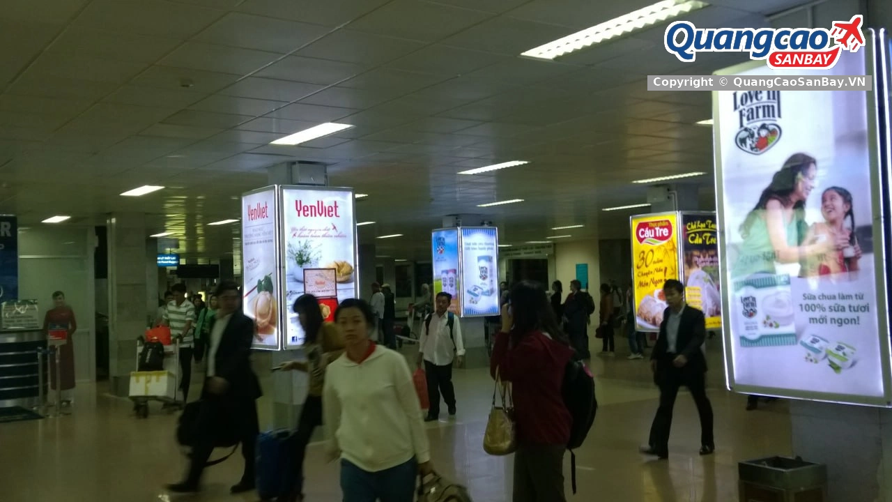Dãy hộp đèn quảng cáo YenViet, MILO, Dr Thanh, TH True Milk tại hành lang đông đúc sân bay